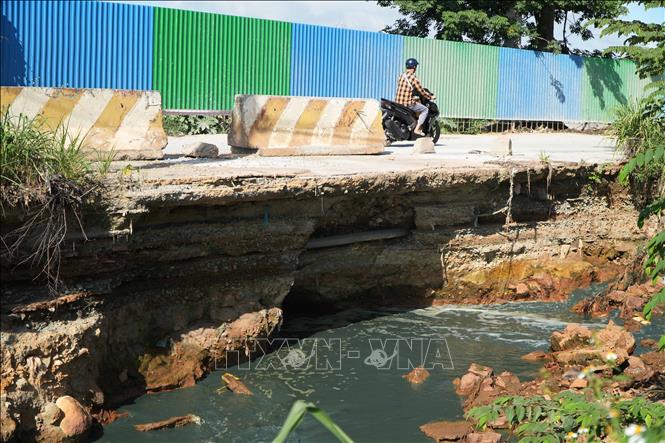 Đoạn đường ven suối Siệp (phường Biên Hòa, thành phố Đồng Nai) bị nước khoét sâu tạo hàm ếch tiềm ẩn nguy hiểm cho người tham gia giao thông. Ảnh: Lê Xuân - TTXVN