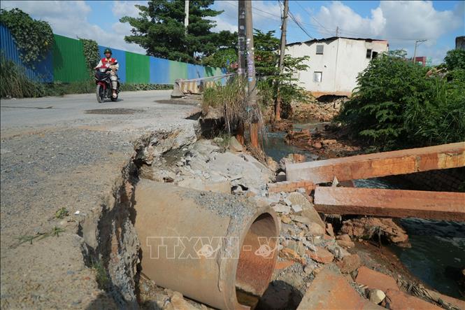 Nước chảy mạnh cuốn trôi đất đá khiến đoạn đường ven suối hư hỏng. Ảnh: Lê Xuân - TTXVN