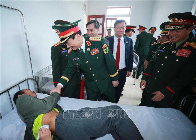 Hai Phó Thủ tướng, Bộ trưởng Quốc phòng thăm hỏi bệnh nhân đang điều trị tại Trạm y tế quân dân y bản Xốp Tờng, tỉnh Bolikhamxay (Lào). Ảnh: Trọng Đức - TTXVN