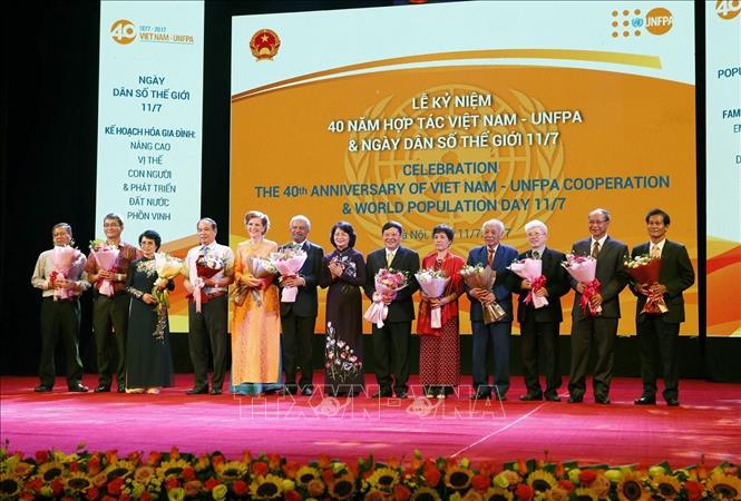 Phó Chủ tịch nước Đặng Thị Ngọc Thịnh tặng hoa các đại biểu dự Lễ mít tinh kỷ niệm 40 năm hợp tác Việt Nam - Quỹ Dân số Liên hợp quốc (UNFPA) và ngày Dân số Thế giới (11/7) với chủ đề “Kế hoạch hóa gia đình: Nâng cao vị thế con người và phát triển đất nước phồn vinh” do Bộ Y tế phối hợp với Quỹ Dân số Liên hợp quốc (UNFPA) tại Việt Nam tổ chức (Hà Nội, 11/7/2017). Ảnh: Dương Ngọc - TTXVN