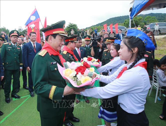Học sinh Trường Tiểu học Thongnammoun đón hai Phó Thủ tướng, Bộ trưởng Quốc phòng. Ảnh: Trọng Đức - TTXVN