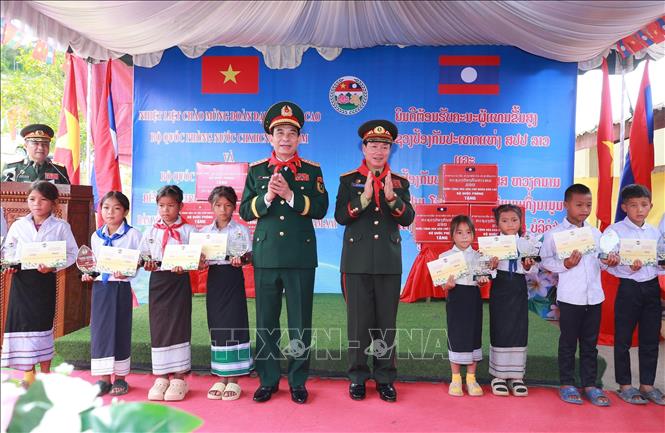 Hai Phó Thủ tướng, Bộ trưởng Quốc phòng tặng quà học sinh Trường Tiểu học Thongnammoun.  Ảnh: Trọng Đức - TTXVN