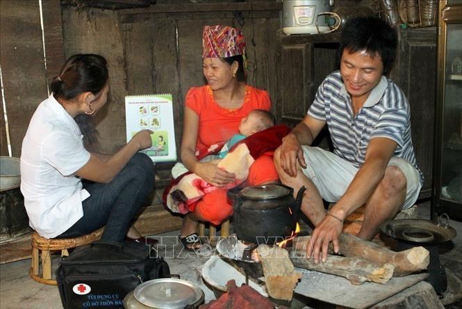 Nhân viên y tế thôn bản hướng dẫn bà mẹ chăm sóc trẻ sơ sinh tại xã Tà Cạ, huyện miền núi Kỳ Sơn, Nghệ An. Ảnh: Dương Ngọc - TTXVN