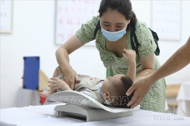 Cân, đo chiều cao cho trẻ trước khi uống Vitamin A. Ảnh: Minh Quyết - TTXVN