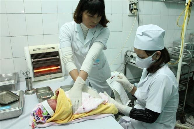 Nhân viên y tế lấy máu gót chân của trẻ sơ sinh để sàng lọc các dị tật bẩm sinh tại Bệnh viện huyện Lạng Giang (Bắc Giang). Ảnh: Dương Ngọc - TTXVN