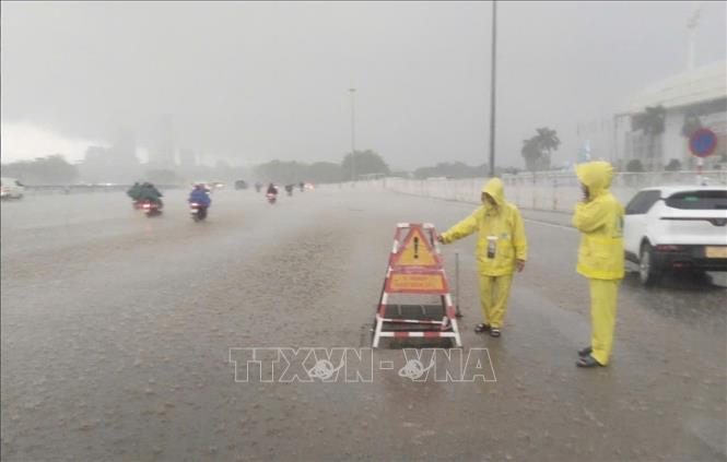 Công nhân ứng trực thoát nước trên đường Lê Quang Đạo (khu vực Sân vận động Mỹ Đình). Ảnh: Nguyễn Thắng - TTXVN