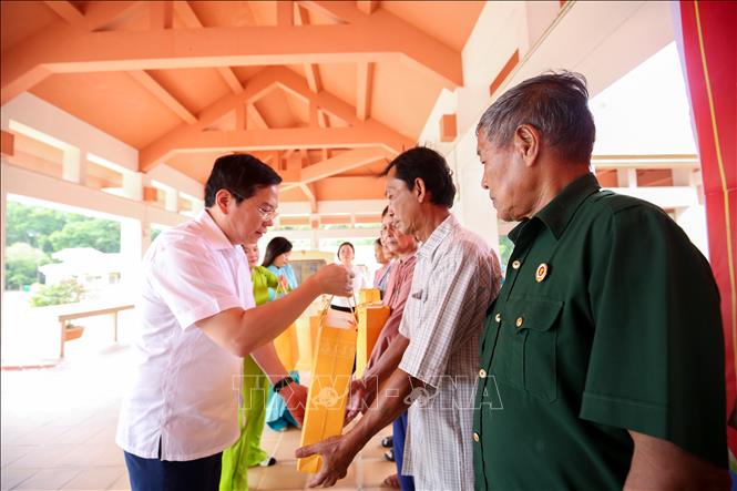Phó Chủ nhiệm Văn phòng Chủ tịch nước Nguyễn Tiến Dũng trao quà tặng gia đình chính sách. Ảnh: Giang Phương - TTXVN