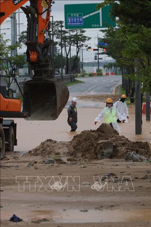 Công nhân dọn bùn trên một đoạn đường ngập lụt sau mưa lớn ở Sejong, Hàn Quốc ngày 9/7/2026. Ảnh: Yonhap/TTXVN phát