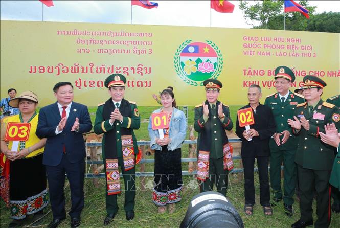 Hai Phó Thủ tướng, Bộ trưởng Bộ Quốc phòng 2 nước tặng bò giống cho nhân dân vùng biên. Ảnh: Trọng Đức - TTXVN