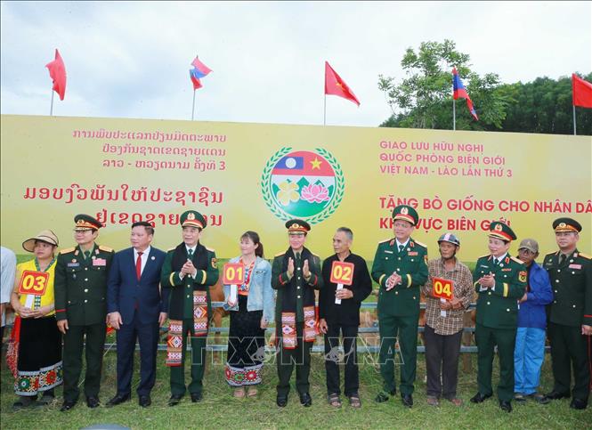 Hai Phó Thủ tướng, Bộ trưởng Bộ Quốc phòng 2 nước tặng bò giống cho nhân dân vùng biên. Ảnh: Trọng Đức - TTXVN