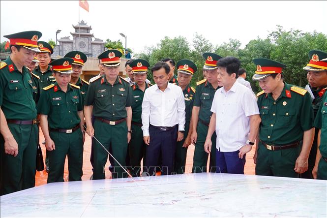 Các đại biểu tham gia khảo sát thực địa, xác định các vị trí nghi có hài cốt tại hiện trường. Ảnh: Tường Vi - TTXVN
