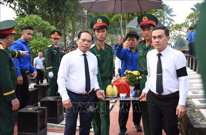 Phó chủ tịch UBND thành phố Đồng Nai Lê Trường Sơn (bên phải) thực hiện nghi thức đưa tiễn 63 hài cốt liệt sỹ. Ảnh: Đậu Tất Thành – TTXVN.