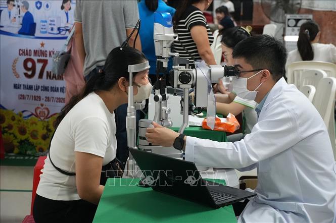 Bác sĩ khám mắt cho đoàn viên, người lao động An Giang. Ảnh: Lê Huy Hải - TTXVN