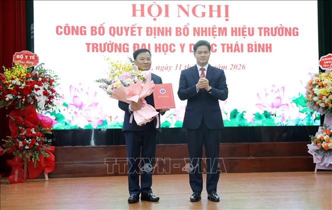 Thứ trưởng Thường trực Bộ Y tế Vũ Mạnh Hà trao quyết định và tặng hoa chúc mừng PGS. TS Nguyễn Duy Cường. Ảnh: Thế Duyệt – TTXVN 