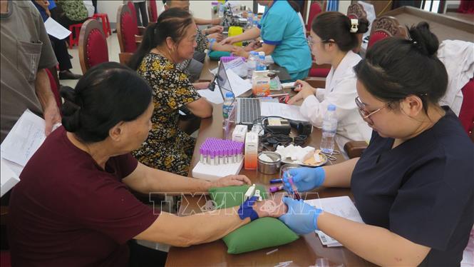 Lấy mẫu sinh phẩm ADN của thân nhân các liệt sĩ. Ảnh: Hương Thu - TTXVN                                