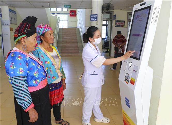 Hướng dẫn bệnh nhân thực hiện đăng kí khám bệnh bằng thẻ CCCD gắn chip tại Trung tâm Y tế Thanh An (Điện Biên). Ảnh: Xuân Tư - TTXVN