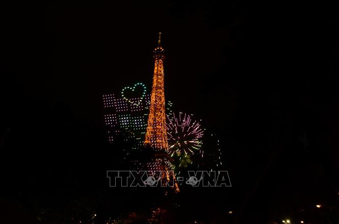 Các thiết bị bay không người lái (drone) tạo hình trên bầu trời, cạnh Tháp Eiffel trong chương trình trình diễn ánh sáng chào mừng Quốc khánh Pháp tại Paris tối 13/7/2026. Hữu Chiến - PV TTXVN tại Pháp