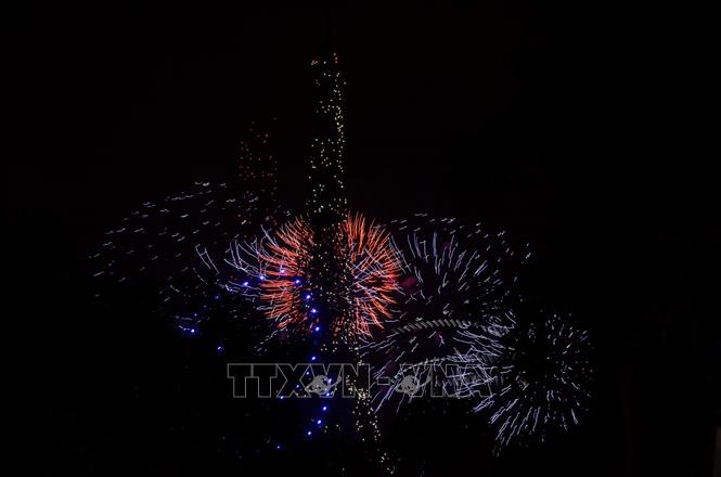 Pháo hoa kết hợp hiệu ứng ánh sáng từ drone tạo nên khung cảnh rực rỡ quanh Tháp Eiffel trong đêm 13/7 tại Paris. Hữu Chiến - PV TTXVN tại Pháp