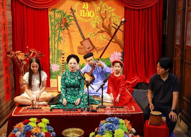 Các bạn trẻ trải nghiệm nghệ thuật ca trù truyến thống. Ảnh: Khánh Hoà - TTXVN
