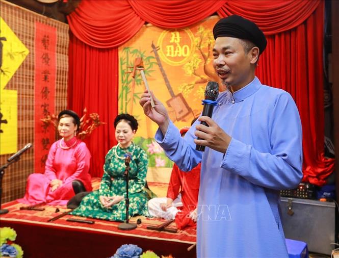 Nghệ nhân giới thiệu tới khán giả các nhạc cụ của nghệ thuật ca trù. Ảnh: Khánh Hoà - TTXVN
