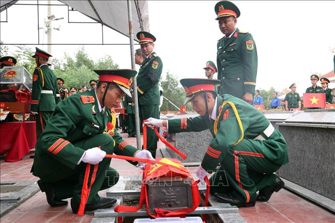 Truy điệu, an táng 5 hài cốt liệt sĩ được tìm thấy tại hang Đá Sập. Ảnh: Trần Tĩnh - TTXVN