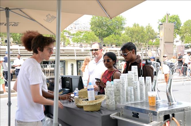 Du khách mua đồ uống giải khát tại một quầy phục vụ ven sông Seine ở thủ đô Paris trong thời tiết nắng nóng, ngày 14/7/2026. Ảnh: Hữu Chiến - PV TTXVN tại Pháp