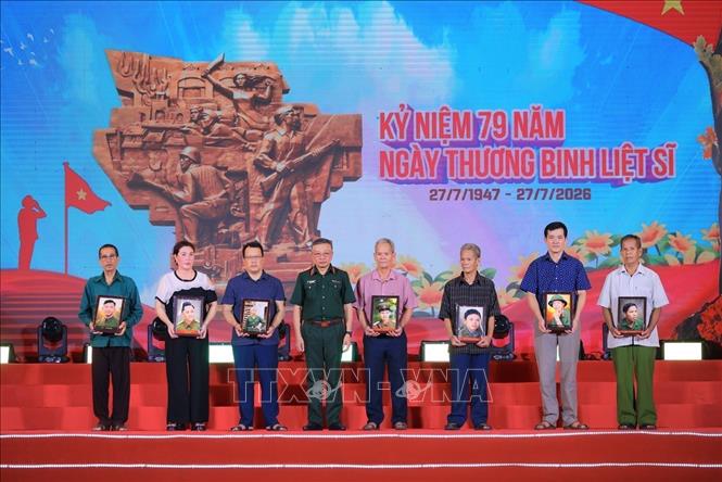 Đồng chí Thượng tướng Lê Quang Minh, Phó Chủ nhiệm Tổng cục Chính trị Quân đội nhân dân Việt Nam tặng di ảnh phục chế cho thân nhân liệt sĩ. Ảnh: Hoàng Hiếu - TTXVN