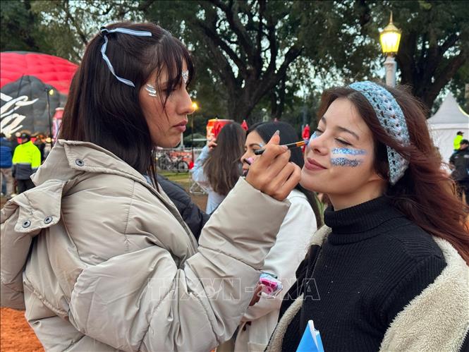 Người hâm mộ vẽ hình cờ Argentina lên mặt cổ vũ đội tuyển. Ảnh: Diệu Hương - PV TTXVN tại Achentina