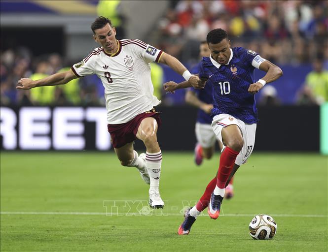 Tiền đạo Kylian Mbappe (phải) của Pháp quyết liệt tranh chấp với tiền vệ Fabian Ruiz của Tây Ban Nha ở khu vực giữa sân. Ảnh: THX/TTXVN phát