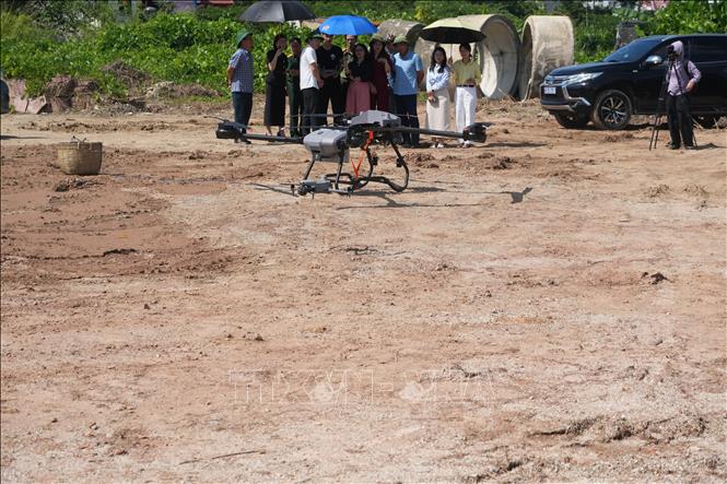 UAV cỡ nhỏ giám sát và UAV cỡ lớn mang vác đồ thực hiện nhiệm vụ. Ảnh: Tiến Vĩnh –TTXVN 