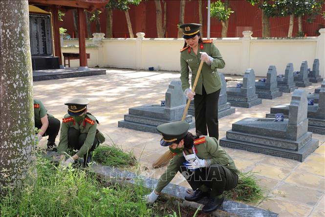 Cán bộ chiến sĩ Công an tỉnh Bắc Ninh dọn dẹp và dâng hương tại trang liệt sĩ Bắc Lý, xã Xuân Cẩm. Ảnh: Danh Lam - TTXVN