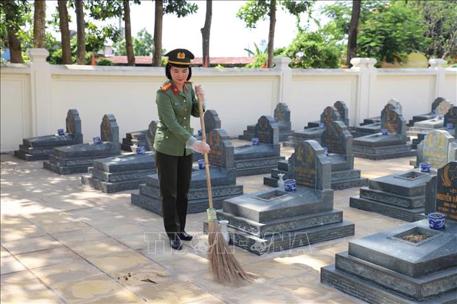 Cán bộ chiến sĩ Công an tỉnh Bắc Ninh dọn dẹp và dâng hương tại Nghĩa trang liệt sĩ Bắc Lý, xã Xuân Cẩm. Ảnh: Danh Lam - TTXVN