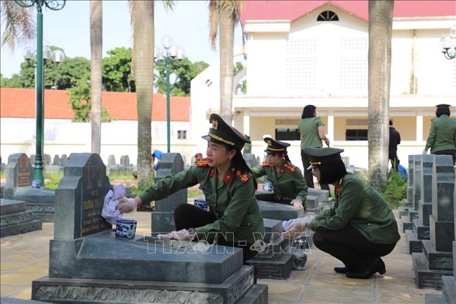 Cán bộ chiến sĩ Công an tỉnh Bắc Ninh dọn dẹp và dâng hương tại Nghĩa trang liệt sĩ Bắc Lý, xã Xuân Cẩm. Ảnh: Danh Lam - TTXVN