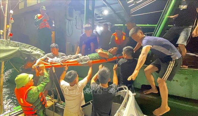 Ngư dân Trần Huy Biên được cán bộ chiến sĩ Đồn Biên phòng Quỳnh Thuận, Bộ đội Biên phòng Nghệ An, cứu hộ, đưa vào bờ cấp cứu an toàn. Ảnh: TTXVN phát