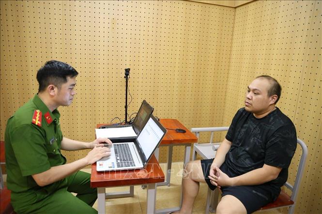 Cơ quan công an lấy lời khai các đối tượng trong đường dây rửa tiền. Ảnh: TTXVN phát