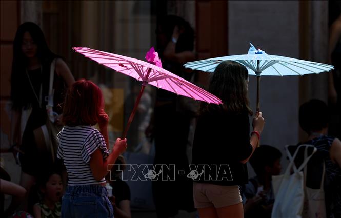 Khách du lịch che ô tránh nắng nóng tại Rome, Italy, ngày 10/7/2026. Ảnh: THX/TTXVN phát