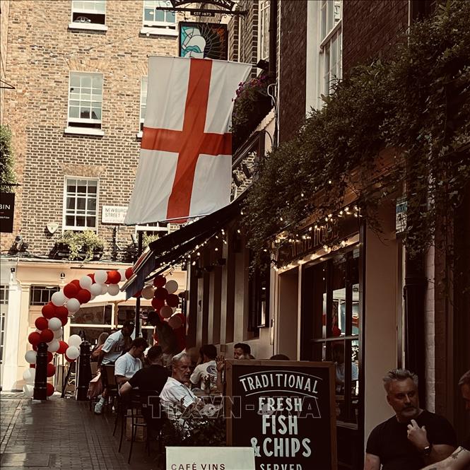 Trong những con ngõ nhỏ của London, bản sắc Anh hiện lên rõ nét qua lá cờ Thánh George, những quán pub và nhịp sống thường nhật trước giờ đội tuyển bước vào trận bán kết World Cup với Argentina. Ảnh: Hương Giang - PV TTXVN tại Anh