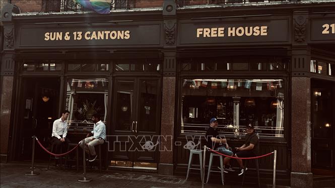 Dây treo cờ các quốc gia dự World Cup 2026 giăng ngang mặt tiền một quán pub trước trận bán kết Anh - Argentina. Ảnh: Hương Giang - PV TTXVN tại Anh