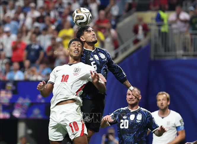 Tiền vệ Jude Bellingham của Anh bật cao tranh chấp bóng bổng với hậu vệ Lisandro Martinez của Argentina. Ảnh: THX/TTXVN phát 