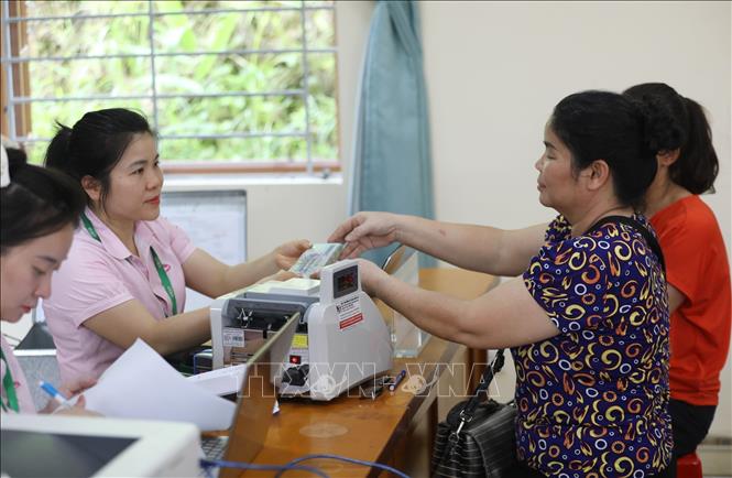 Cán bộ Chi nhánh Ngân hàng Chính sách xã hội tỉnh Lạng Sơn làm thủ tục tiếp nhận tiền nợ đến hạn, tiền lãi của hộ vay ủy thác qua Hội Liên hiệp Phụ nữ tỉnh Lạng Sơn tại điểm giao dịch Mai Pha. Ảnh: Anh Tuấn – TTXVN