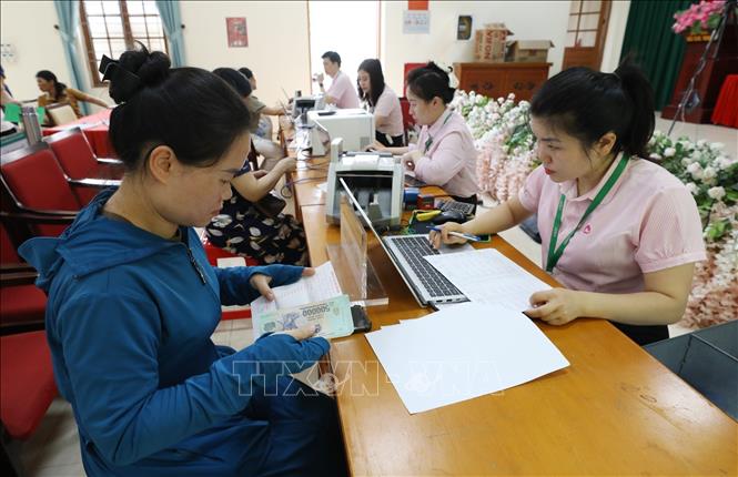 Cán bộ Chi nhánh Ngân hàng Chính sách xã hội tỉnh Lạng Sơn làm thủ tục tiếp nhận tiền nợ đến hạn, tiền lãi của hộ vay ủy thác qua Hội Liên hiệp Phụ nữ tỉnh Lạng Sơn tại điểm giao dịch Mai Pha. Ảnh: Anh Tuấn – TTXVN