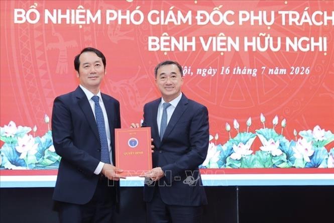 Thứ trưởng Bộ Y tế Trần Văn Thuấn (bên phải) trao Quyết định bổ nhiệm Phó Giám đốc phụ trách chuyên môn Bệnh viện Hữu Nghị. Ảnh: Minh Quyết - TTXVN