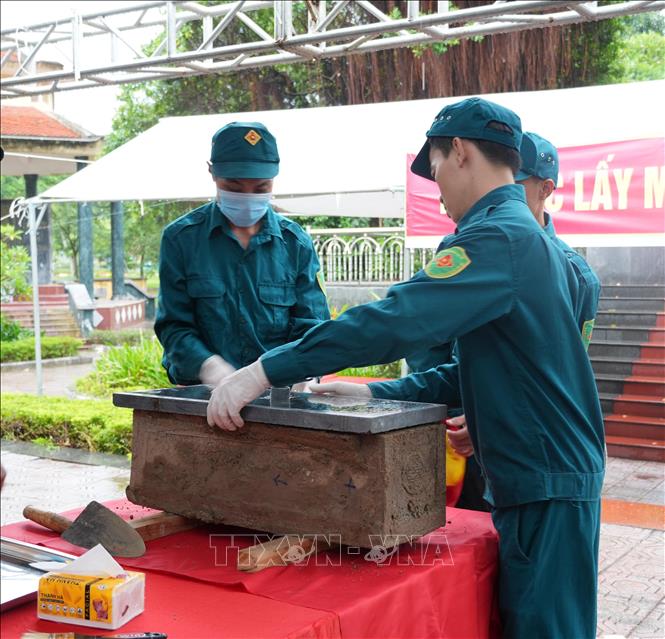 Lực lượng chức năng thực hiện quy trình kỹ thuật lấy mẫu, bảo quản sinh phẩm phục vụ giám định ADN. Ảnh: Nguyễn Thảo - TTXVN
