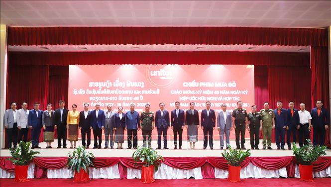 Đại biểu hai nước chụp ảnh kỷ niệm nhân buổi chiếu bộ phim điện ảnh đặc biệt “Mưa đỏ” tại Lào. Ảnh: Xuân Tú - PV TTXVN tại Lào