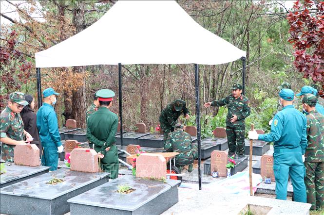 Lực lượng chuyên môn triển khai cất bốc mộ liệt sĩ cần lấy mẫu hài cốt để giám định AND tại Nghĩa trang Liệt sĩ Lâm Đồng. Ảnh: Nguyễn Thanh - TTXVN