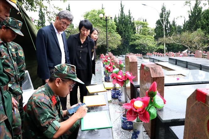 Lực lượng chuyên môn xác định thông tin mộ liệt sĩ cần lấy mẫu hài cốt tại Nghĩa trang Liệt sĩ Lâm Đồng. Ảnh: Nguyễn Thanh - TTXVN