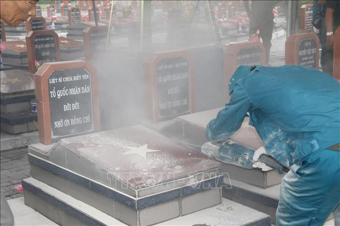 Lực lượng chuyên môn triển khai bốc mộ lấy mẫu hài cốt tại Nghĩa trang Liệt sĩ xã Đức Linh. Ảnh: Nguyễn Thanh - TTXVN