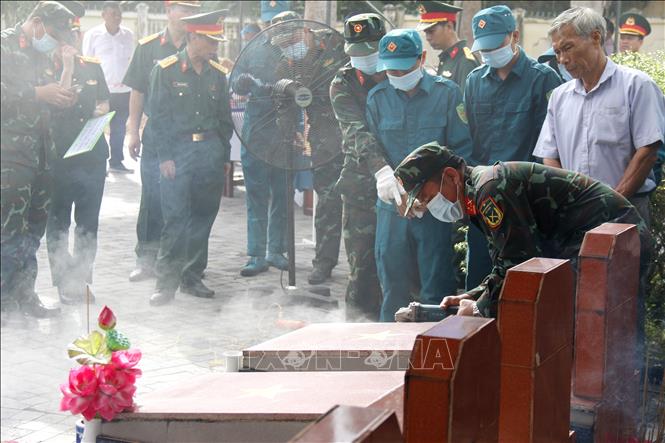 Lực lượng chuyên môn triển khai bốc mộ lấy mẫu hài cốt tại Nghĩa trang Liệt sĩ xã Đức Linh. Ảnh: Nguyễn Thanh - TTXVN