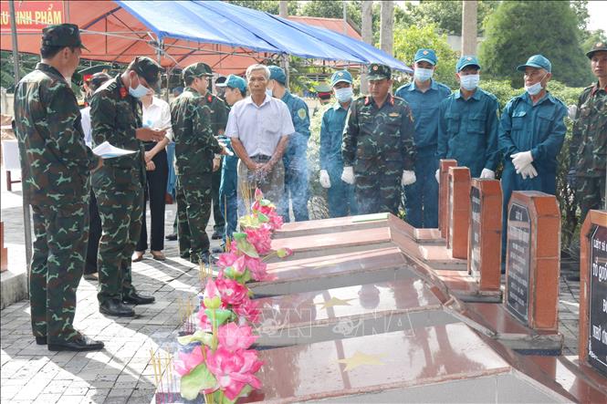 Các đơn vị triển khai xác định thông tin mộ liệt sĩ cần lấy mẫu hài cốt tại Nghĩa trang Liệt sĩ xã Đức Linh. Ảnh: Nguyễn Thanh - TTXVN