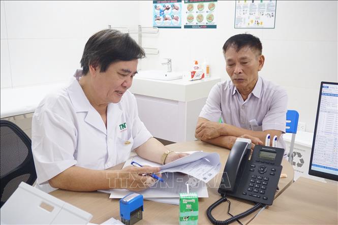 Bác sĩ đọc kết quả xét nghiệm và đưa ra phác đồ điều trị bệnh cho người có công của tỉnh. Ảnh: Tiến Vĩnh –TTXVN                             